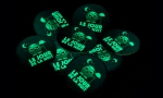 Panachage de badges ronds 45mm sur fond phosphorescent.
Visuel : 'Le jour de la nuit. Chouette éteignant la lumière'